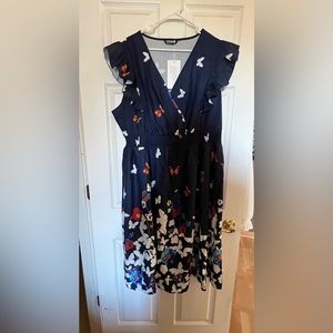 BloomChic ruffled sleeveless navy dress covered in butterflies. Below the knee.